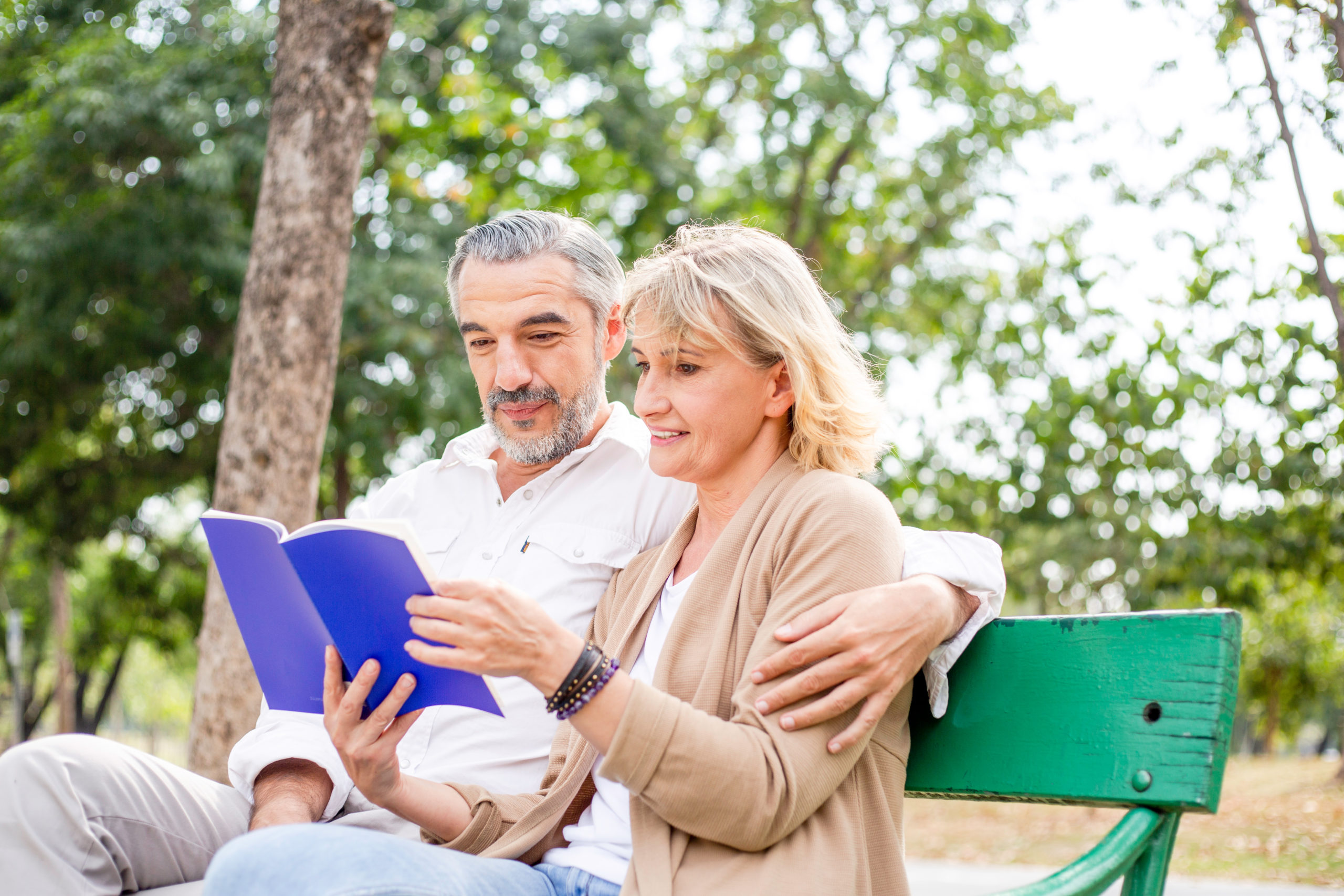 man en vrouw op een bank een boek aan het lezen