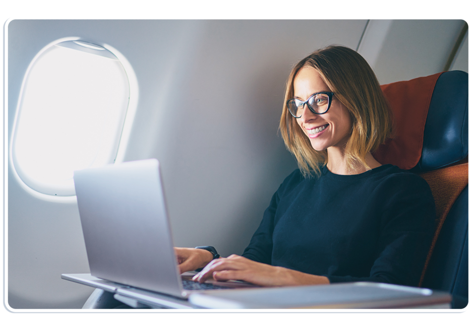 vrouw met bril die lachend naar laptopscherm lacht